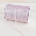 Detailed macro view of light pink metallic glitter ribbon on white plastic spool roll - Pink
