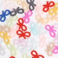 Close-up of colorful beaded bow charms for DIY accessories and nail art decoration - Hollow Bow Style / 18x10mm (Approx. 100 Pieces/Pack) / Random Mixed Colors