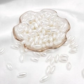 Oval white faux pearl beads for DIY jewelry making on silk background in a glass tray - Rice Bead / 6x12mm 100 Pieces/Pack / White