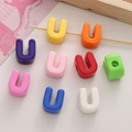 Colorful U-shaped acrylic beads for DIY jewelry making displayed on a wooden stick - Letter U
