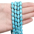 Perles en turquoise synthétique en forme de goutte avec veines brunes tenues en main - Goutte d'eau plate / 8x11mm (38cm/Paquet) / Bleu ciel