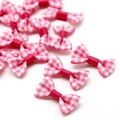 Detail van roze geruite mini-strikjes voor DIY-haaraccessoires en knutselprojecten - Rozerood