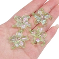 Green AB coated acrylic flower charms for DIY jewelry making displayed on a palm - Lily Shape / 4 Pieces/Pack (Approx. 30x30mm) / Green