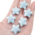 Cuentas de estrella azul cielo en acrílico para joyería DIY mostradas sobre una palma - 23x22mm Agujero Aprox 2mm 2 Piezas/Paquete / Azul claro