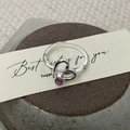 Detail shot of an S925 silver ring with a pink zircon in a double heart hollow design - US Size 6 / Pink Purple Gemstone