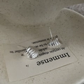 Nahaufnahme von S925 Silbermuschel-Ohrsteckern mit Spiralstruktur auf Keramik - 925er Silber / Silber