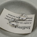 Detail view of silver streamlined earrings with three inset zircons on textured backdrop - 925 Silver / Silver