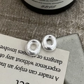 Dettaglio di orecchini a ciambella in argento 925 con finitura martellata artigianale - Argento 925 / Argento