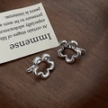 Dettaglio di orecchini a fiore in argento S925 con marchio 925 su base in legno - Argento 925 / Argento