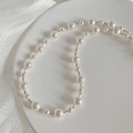 Macro shot of elegant white pearls and silver spacer beads on a silk fabric - 925 Silver / Silver