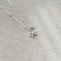 Macro detail of S925 silver bow pendant necklace with a sparkling round zircon stone - 925 Silver / Silver