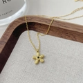Dettaglio della collana con ciondolo a fiore dorato, trama martellata e gemma nera centrale - Argento 925 / Oro 18k