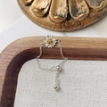 Détail d'une bague marguerite ajustable en argent 925 avec chaîne et boule coulissante - Bague Chaîne Extensible Marguerite