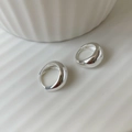Dettaglio di orecchini ovali in argento S925 minimalisti su un vassoio di ceramica - Argento