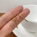 Gros plan de boucles d'oreilles nœud dorées à la main montrant taille et finition - Argent 925 / Or