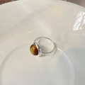 Makroansicht eines S925 Sterling Silberrings mit rundem bernsteinfarbenem Tigerauge-Stein - Einstellbar Offen / Silberner Tigerauge-Ring