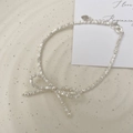 Macro detail of S925 silver bow bracelet with crushed silver beads on a ceramic plate - 925 Silver / Silver