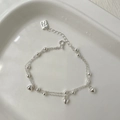 Dettaglio di un bracciale a doppio strato in argento S925 con ciondoli a cuore e perle - Argento 925 / Argento