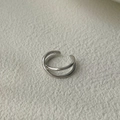 Detailed close-up of a minimalist silver double-layer X-shaped ear cuff on beige fabric - 925 Silver / White Gold (Single)