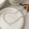 Detail shot of a S925 silver bow pendant and round white pearl necklace with lobster clasp - Necklace / 925 Silver