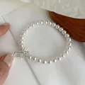 Detailansicht eines eleganten Perlenarmbands mit silbernem Schleifenanhänger - Armband / 925er Silber