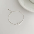 Detail of S925 sterling silver braided knot bracelet with heart-shaped twist and drop charm - 925 Silver / Silver
