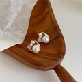 Gros plan sur boucles d'oreilles en argent 999 avec nœuds en zircon et perles blanches - 99 Argent / Argent