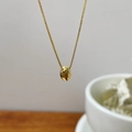 Detailed view of a polished gold oval bean pendant on a delicate box chain necklace - 925 Silver / Gold