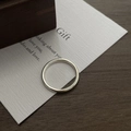 Close-up of minimalist polished silver ring placed on a decorative white gift card - HK Size 10