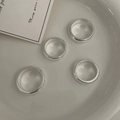 Detailed close-up of four thick polished silver rings set inside a white ceramic dish - US 4 / Silver