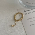 Detail of adjustable golden double-layered beaded ring with hanging sphere charm detail - Adjustable Open / Gold