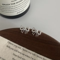 Nahaufnahme von S925 Silber Schleifenohrringe mit Zirkonia auf einem Holzständer - Schleifen-Stil (Echt Silber Farbe) / 925er Silber