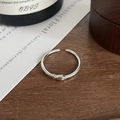 Macro shot of silver fish ring with a small zircon eye on a natural wood surface - Adjustable Open / Silver