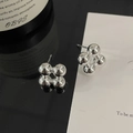 Dettaglio macro di orecchini a lobo in argento con design a quattro sfere lucide a matrice - Argento