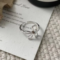 Vista macro di un anello a nodo floreale in argento su cartolina di poesia vintage - Aperto Regolabile / Argento