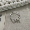 Dettaglio dell'anello in argento 925 intrecciato con due mini perle su sfondo di tela - Aperto Regolabile / Argento