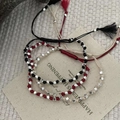 Detailansicht von handgeflochtenen Armbändern mit Silberperlen und Quasten - 925er Silber / Schwarz