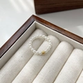 Macro detail of elastic pearl ring with gold bead in a velvet jewelry display box - One Size / Gold