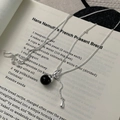 Détail du collier gourde en argent avec une pierre noire sur papier vintage - Argent 925 / Agate noire