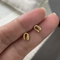 Makro-Detail minimalistischer goldener U-Ohrstecker mit matter gebürsteter Textur - 925er Silber / Gold