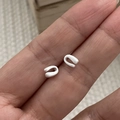 Macro view of minimalist S925 sterling silver U-shaped stud earrings in hand - 925 Silver / Silver