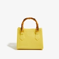 Glossy yellow PVC handbag with bamboo handle and gold hardware in trapezoid shape - Yellow