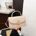 Beige lychee textured crossbody bag with top handle and round metal swivel lock - Apricot