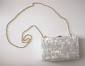 Detail der gestreiften Perlmutt-Acryl-Abendtasche mit goldener Ketten-Schulterriemen - Weiß
