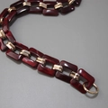 Dettaglio macro dei maglioni in resina vintage con trama marmo e connettori dorati - Rosso scuro