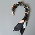 Dettaglio foulard in seta intrecciato con catena dorata per decorazione borsa a mano - Stile Foglia Piuma Nero (5)