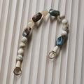 Detalle de cadena de perlas de resina veteada con cierres circulares metálicos dorados - 42cm / Estilo 1
