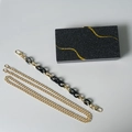Elegante schwarze Glitzer-Acryl-Clutch mit goldenen Details und variablen Kettenriemen - Zwei Ketten