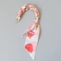 Close-up of golden metal chain handle interwoven with pink silk scarf for handbags - Red Polka Dot Style