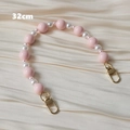 Détail d'une sangle en perles rose et blanc de 32cm avec fermoirs mousquetons dorés - Style Poignée 32cm / Rose